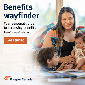 A smiling Indigenous mother holding a baby and young child sitting together on a couch in front of books on a table.